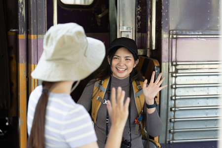backpack woman and man say hi each other at train station, to travel during holidayの写真素材