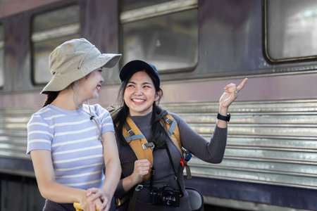 Two female friend talking about trip on their way to train. traveling conceptの写真素材