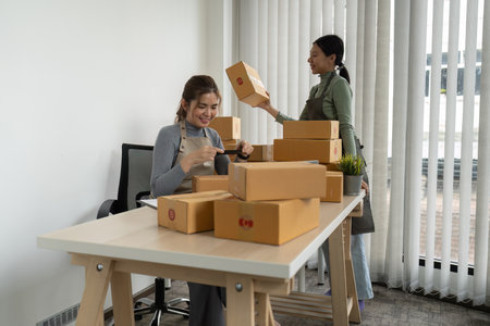 Young woman online business owner is preparing a parcel box to prepare the package for delivery to...