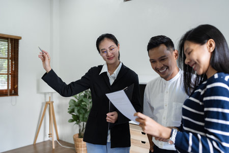 young couple with a real estate agent visiting home for buy or for rentの写真素材