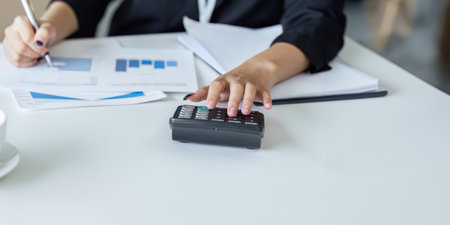 Businesswoman working with document and using calculator for checking finance report