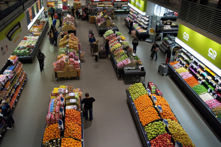 Supermarket has a wide aisle full of fruit and vegetables, bright lighting from bulbs. Generative AIの素材