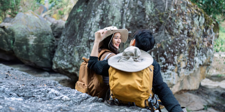Lesbian couple relaxing together on rock at a hiking trail While traveling together on a hiking...
