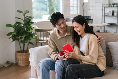 Young couple celebrating and giving present on Valentines Day. Romantic day together. Valentines Day conceptの写真素材