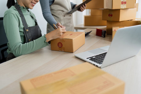 Asian woman write parcel box to prepare for delivery to customer. e-business concept