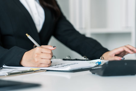 Female accountant working about financial with calculator at her office, Savings, Finances and economy conceptの写真素材
