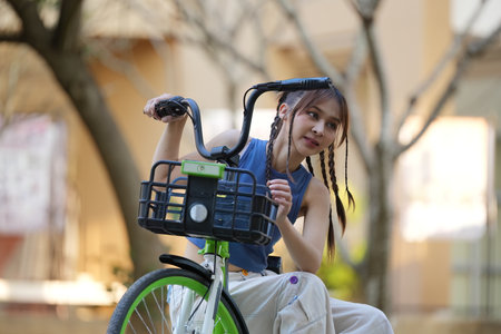 Happy Asian young woman ride bicycle in park, street city her smiling using bike of transportation,...
