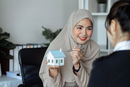 Real estate agent talked about the terms of the home purchase agreement and asked the customer to sign the documents to make the contract legallyの写真素材