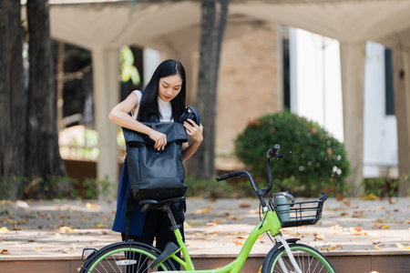 Asian young businesswoman bike to work for eco friendly green energy and listen music with headphone...