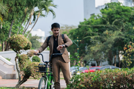 Young businessman in suit in city park bike to work eco friendly alternative vehicle green energyの写真素材