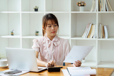 accountant working on desk using calculator for calculate finance report in officeの写真素材