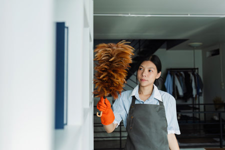 Female housekeeper smile and wearing glove, preparing to clean officeの写真素材