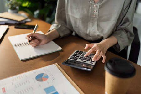 Business finance concept, Business woman using calculator to calculate business data at office