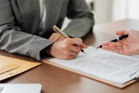 A woman is signing a document with a penの写真素材