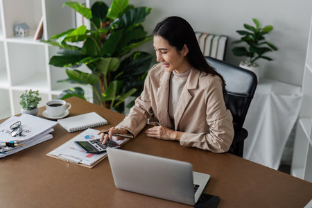 Business finance concept, Business woman using calculator to calculate business data at officeの写真素材