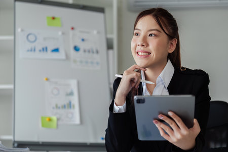 Accountant business woman working with tablet to think strategy and analyzeの写真素材