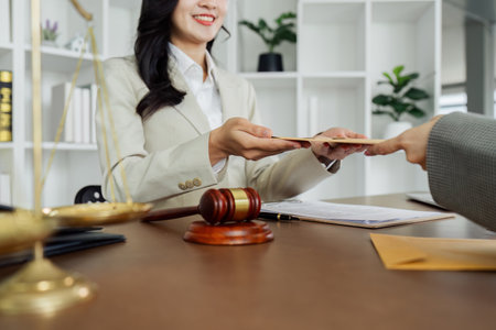 lawyer talks with the client about the lawsuit and receives various documents for further analysis from the clientの写真素材