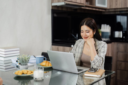 Young business man working at home with laptop and papers on desk. Work from home conceptの写真素材