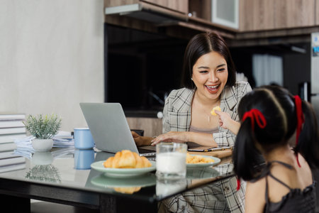 Business woman working from home and her child giving her snacks while workingの写真素材
