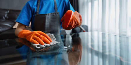 Housekeeping woman wiping the table in the living room House cleaning service conceptの写真素材