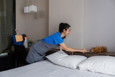 cleaning service woman worker clean bedroom at hotel. housekeeper cleaner feel happy and make bed look neat. housework and housekeeping cleaning serviceの写真素材