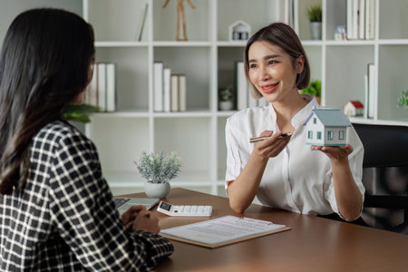 Real estate agent talked about the terms of the home purchase agreement and asked the customer to sign the documentsの写真素材