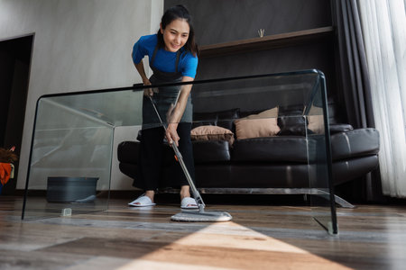 cleaning service housekeeper women swipe floor in living room. House cleaning service conceptの写真素材