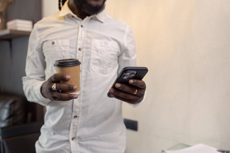African American business man working with document and laptop while talking on mobile at home on couch. work from home conceptの写真素材