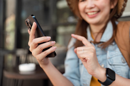 Smiling Traveler Using Smartphone for Navigation and Communication While Exploring a New Cityの写真素材