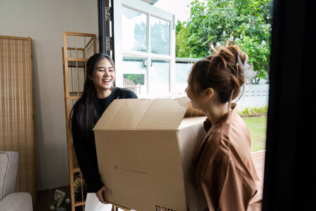 Happy LGBT lesbian Couple Moving into New Home, Carrying Boxes and Smiling, Embracing New Beginnings...