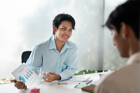 Couple Discussing Financial Plan Investment with Professional Planner in Modern Office Settingの写真素材