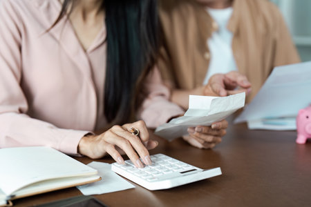 Couple Managing financial at Home, Paying Bills, and Planning Budget Together in a Modern Living Roomの写真素材
