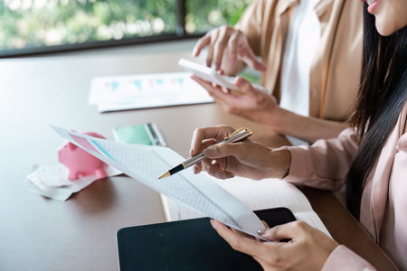 Couple Reviewing Financial Documents and Planning Savings with Bills and Calculator at Home Officeの写真素材