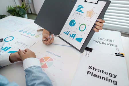 Business Strategy Planning Meeting with Financial Reports and Data Analysis Charts in Modern Officeの写真素材