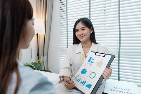 Professional Business Meeting with Smiling Woman Presenting Financial Report in Modern Office...