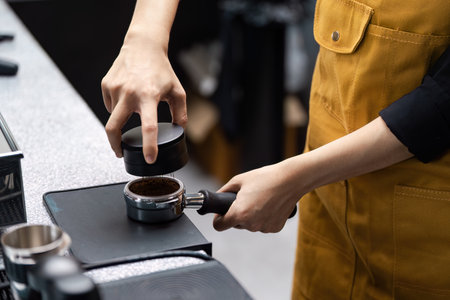 Barista Preparing Espresso in Modern Coffee Shop with Professional Equipment and Toolsの写真素材