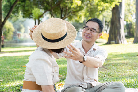 Happy Senior Couple Enjoying Retirement Outdoors in a Park on a Sunny Dayの写真素材