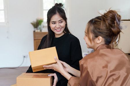 Happy Lesbian Couple Moving into New Home Unpacking Boxes and Smiling Together in Bright Modern Living Roomの写真素材