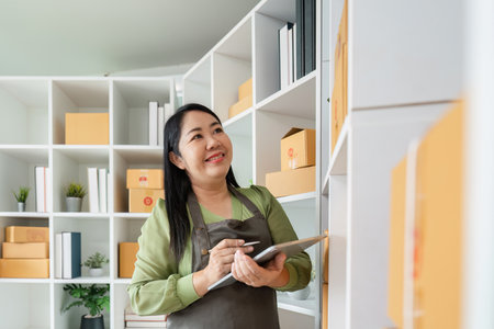 Senior Entrepreneur Organizing Inventory in Modern Office Space for New Business Startupの写真素材