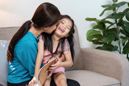 Loving Mother and Daughter Sharing a Happy Moment on the Couch in a Modern Home Setting