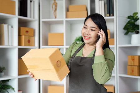 Small Business Owner Managing Orders and Inventory in a Modern Office Spaceの写真素材