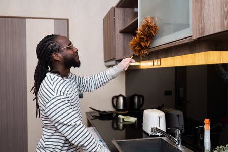 Professional Housekeeper Dusting a Shelf with Feather Duster in a Modern Home Interior