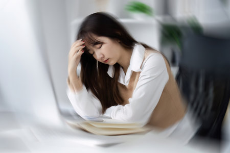 Young Woman Feeling Sick at Work, Experiencing Headache and Fatigue in Office Environment