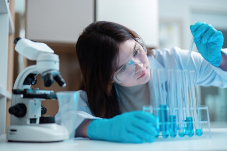 Scientist Conducting Experiment in Modern Laboratory with Advanced Equipment and Glasswareの写真素材