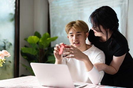 Modern Real Estate Concepts with Young Couple Exploring Property Options Online in Bright Living Spaceの写真素材
