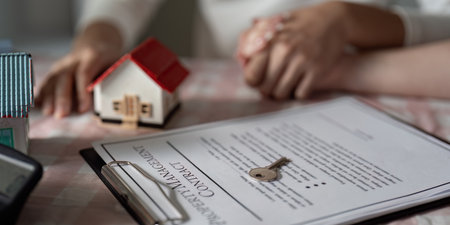Professional Real Estate Agent with House Model and Contract Document in Office Setting
