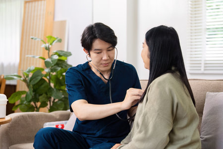 Healthcare Professional Conducting a Routine Check-Up with Patient in a Comfortable Home Settingの写真素材
