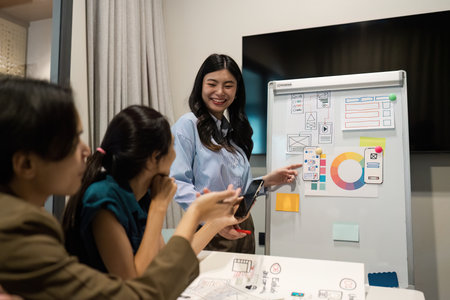 Diverse Team Collaborating in Modern Office Setting with Creative Business Presentation on Whiteboardの写真素材