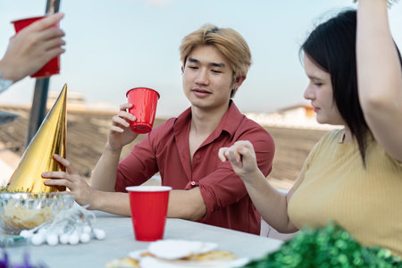 Vibrant Outdoor Party with Friends Enjoying Drinks and Festive Atmosphere Under a Clear Skyの写真素材