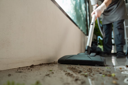 Professional Cleaning Service Worker Vacuuming Outdoor Patio Area with Modern Equipmentの写真素材